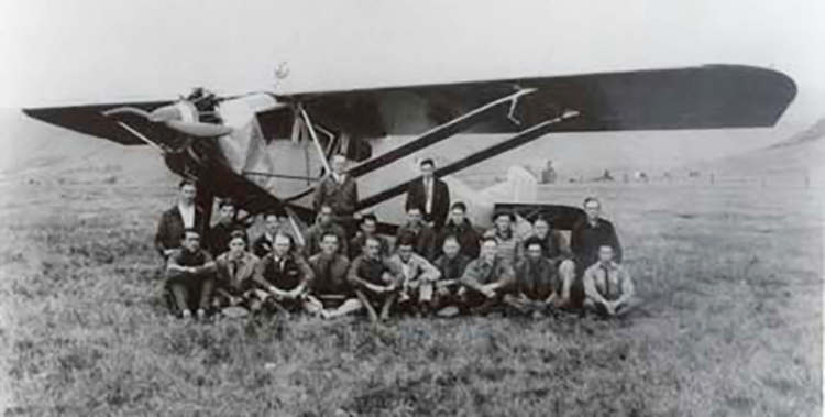 Amelia Earhart with group of students and plane